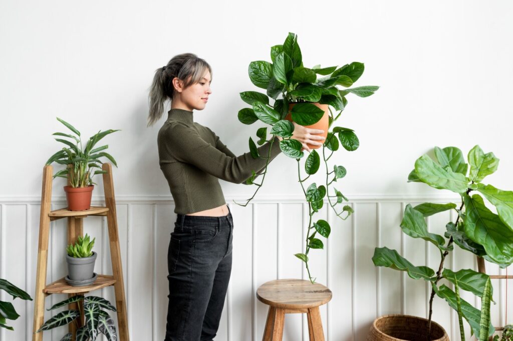 happy-woman-carrying-houseplant