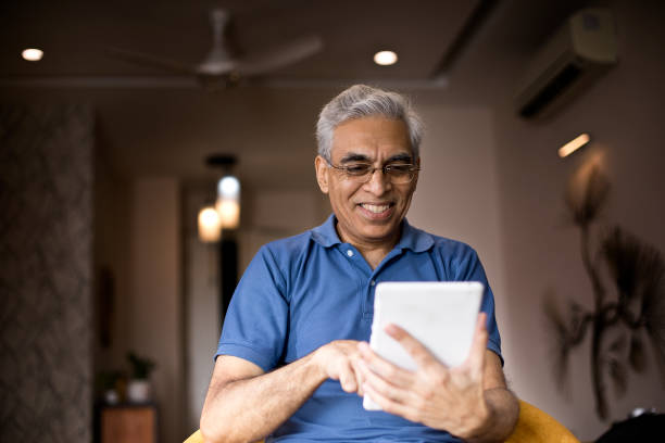 Senior man using digital tablet at home